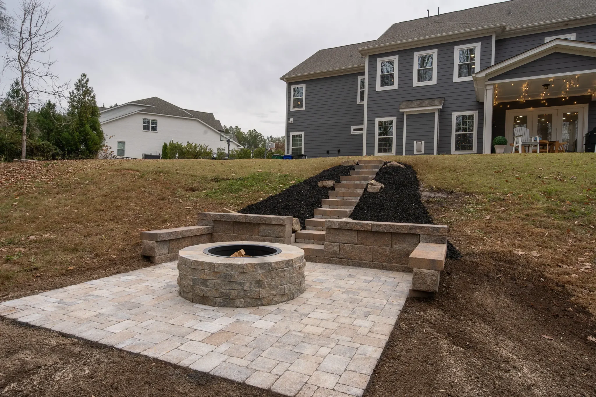 after pictures of the paver patio with the firepit, steps, and retaining / bench wall